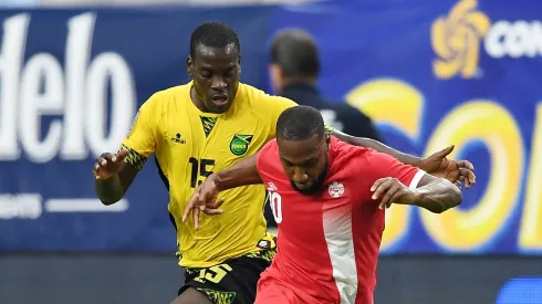 David Junior Hoilett of Canada battles for possession of the ball with Je-Vaughn Watson of Jamaica.