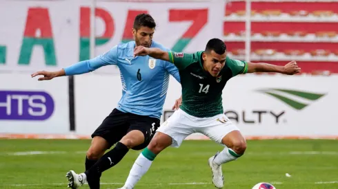 Moises Villarroel of Bolivia fights for the ball with Rodrigo Bentancur of Uruguay.