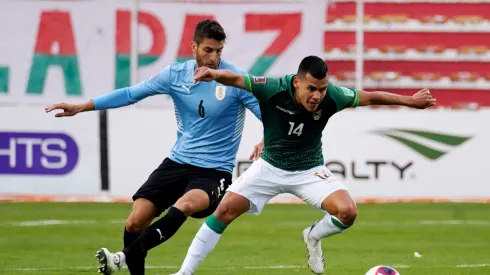 Moises Villarroel of Bolivia fights for the ball with Rodrigo Bentancur of Uruguay.
