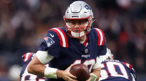Mac Jones of the New England Patriots looks to hand the ball off.