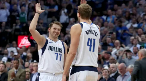 Luka Doncic and Dirk Nowitki celebrating during a Dallas Mavericks game.
