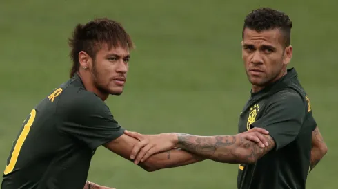 Dani Alves (R) helps Neymar of Brazil stretch during a Brazil training session ahead of the 2014 FIFA World Cup Brazil opening match against Croatia at Arena de Sao Paulo on June 11, 2014 in Sao Paulo, Brazil.
