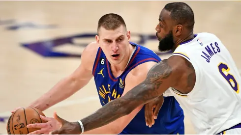 Nikola Jokic #15 of the Denver Nuggets handles the ball against LeBron James #6 of the Los Angeles Lakers
