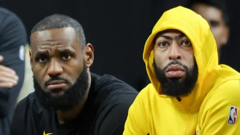 LeBron James and Anthony Davis look worried sitting on the bench during a Los Angeles Lakers game.
