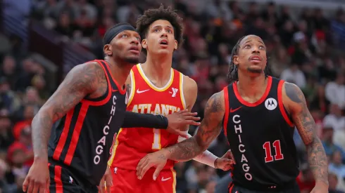 Torrey Craig 13 of the Chicago Bulls and DeMar DeRozan 11 of the Chicago Bulls box out Jalen Johnson 1 of the Atlanta Hawks during the second half at the United Center on April 1, 2024 in Chicago, Illinois.
