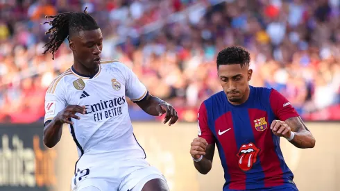 Raphinha of FC Barcelona is tackled by Eduardo Camavinga of Real Madrid during the LaLiga EA Sports match between FC Barcelona and Real Madrid CF at Estadi Olimpic Lluis Companys on October 28, 2023 in Barcelona, Spain.
