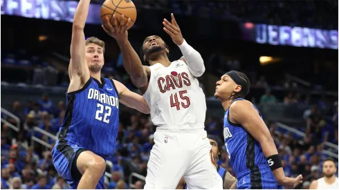 Cleveland Cavaliers' Donovan Mitchell scores between the Orlando Magic's Franz Wagner and Paolo Banchero
