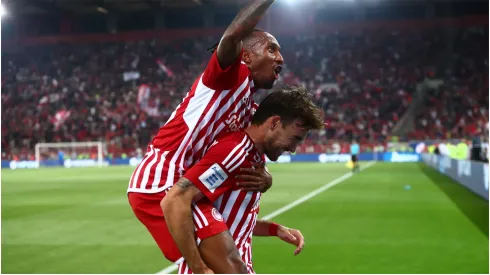 Andre Horta of Olympiacos FC scores and celebrates with his teammates
