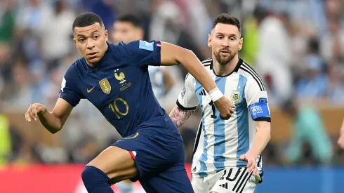 Kylian Mbappe battles for possession with Lionel Messi in the 2022 World Cup final.
