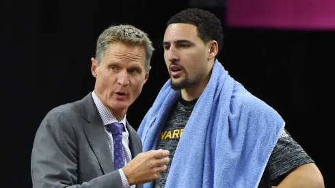 Head coach Steve Kerr of the Golden State Warriors talks to Klay Thompson #11 on the bench during their preseason game against the Los Angeles Lakers at T-Mobile Arena on October 15, 2016 in Las Vegas, Nevada.
