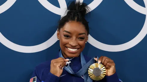 Gold medalist Simone Biles of Team United States poses with the Olympic Rings and a goat charm on her necklace during the Artistic Gymnastics Women's All-Around Final.