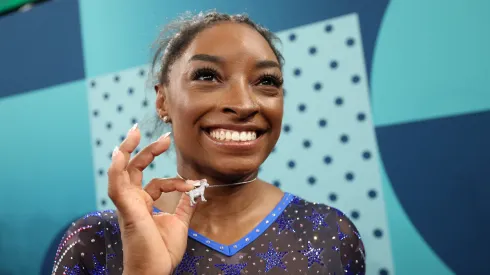 Gold medalist Simone Biles of Team United States poses with a necklace in the likeness of a goat after competing in the Artistic Gymnastics Women's All-Around Final.
