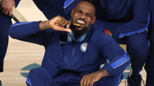 Gold medalist LeBron James of Team United States bites his medal while posing for a photo during the Men's basketball medal ceremony
