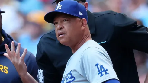Manager Dave Roberts #30 of the Los Angeles Dodgers speaks with umpires prior to a game against the Milwaukee Brewers at American Family Field.