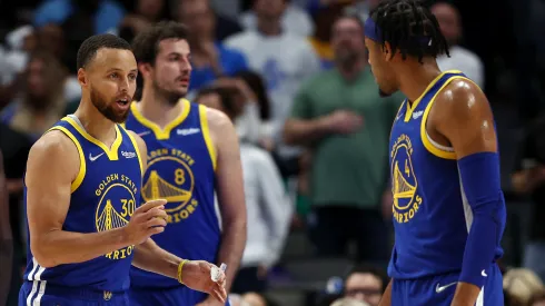 Stephen Curry #30 of the Golden State Warriors talks to teammate Moses Moody #4 during the fourth quarter against the Dallas Mavericks
