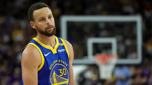 Stephen Curry #30 of the Golden State Warriors stands on the court during a break in the fourth quarter of a preseason game
