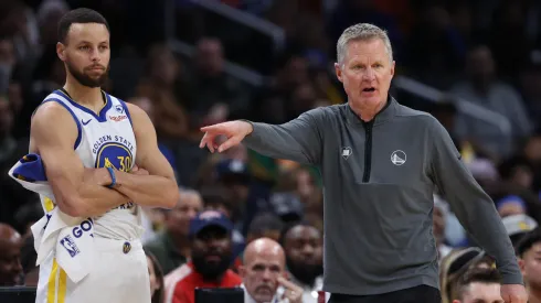 Head coach Steve Kerr of the Golden State Warriors (R) and Stephen Curry #30 of the Golden State Warriors look on against the Washington Wizards during the first half at Capital One Arena
