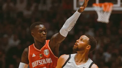 Stephen Curry of USA attempts a three point shot over Dennis Schröder of Germany during a game.
