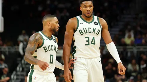 Damian Lillard #0 and Giannis Antetokounmpo #34 of the Milwaukee Bucks walk to the bench during the first half of a preseason game against the Chicago Bulls at Fiserv Forum on October 14, 2024 in Milwaukee, Wisconsin.
