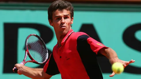 Gustavo Kuerten of Brazil returns in his third round match against Roger Federer of Switzerland during Roland Garros.