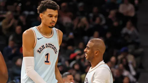 Chris Paul of the San Antonio Spurs is greeted by Victor Wembanyama.