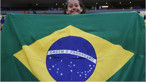 A young fan of Brazil cheers with the Brazilian flag