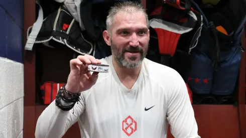 Alex Ovechkin #8 of the Washington Capitals holds the puck from his 894th career goal scored in the locker room after defeating the Chicago Blackhawks at Capital One Arena on April 04, 2025 in Washington, DC. Ovechkin's goal ties him with Wayne Gretzky for the all-time goal scoring record.