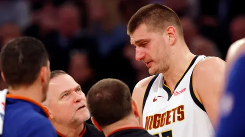 Nikola Jokic #15 reacts with head coach Michael Malone of the Denver Nuggets after an injury to his eye during the first half against the New York Knicks at Madison Square Garden on January 25, 2024 in New York City.