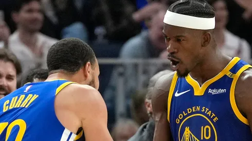 Jimmy Butler III #10 and Stephen Curry #30 of the Golden State Warriors celebrate after Butler scored and was fouled on the shot against the Dallas Mavericks
