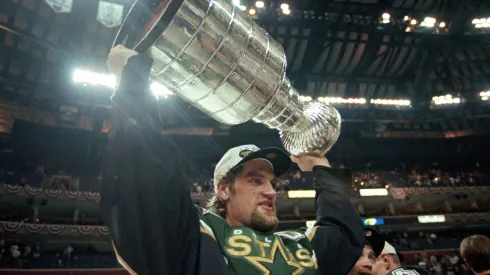 Captain Derian Hatcher of the Dallas Stars carries the Stanley Cup after the Stanley Cup Final game against the Buffalo Sabres in 1999.