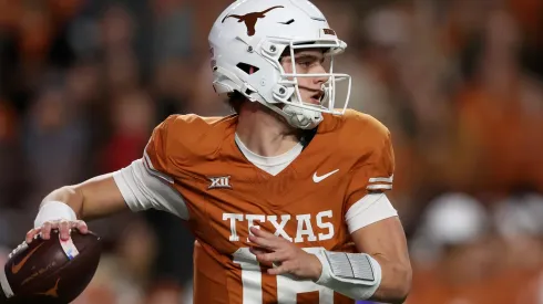 Arch Manning #16 of the Texas Longhorns rolls out to pass in the fourth quarter against the Texas Tech Red Raiders at Darrell K Royal-Texas Memorial Stadium on November 24, 2023 in Austin, Texas.