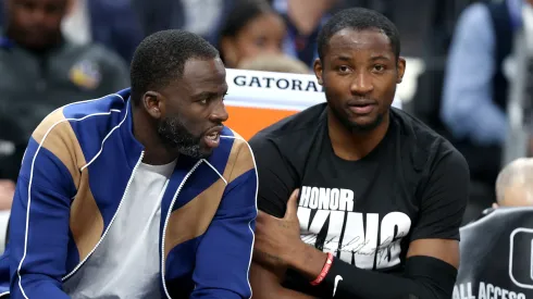 Draymond Green #23 (left) speaks to Jonathan Kuminga #00 of the Golden State Warriors on the bench during their game against the New Orleans Pelicans in the first half at Chase Center on January 10, 2024 in San Francisco, California.