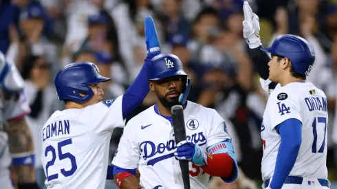 Shohei Ohtani #17 of the Los Angeles Dodgers celebrates his sacrifice fly to score Tommy Edman #25 behind Teoscar Hernández #37 and Francisco Alvarez #4 of the New York Mets.