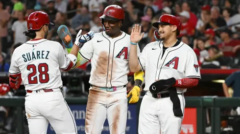 Eugenio Suarez #28 of the Arizona Diamondbacks celebrates with Geraldo Perdomo #2 and Josh Naylor #22 after hitting a three run home run.
