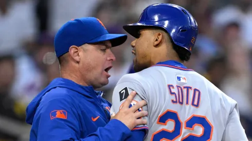 Juan Soto #22 of the New York Mets is held back by manager Carlos Mendoza #64 after being called out on strikes by home plate umpire Emil Jimenez #82 during the third inning at Petco Park on July 28, 2025 in San Diego, California.