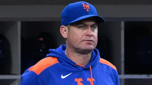 Manager Carlos Mendoza #64 of the New York Mets looks on from the dugout.