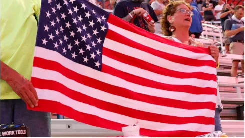 Fans hold an American flag