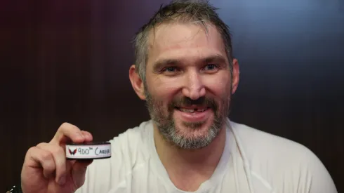 Alex Ovechkin #8 of the Washington Capitals poses with the puck of his 900th career NHL goal.
