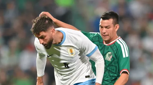 Rodrigo Bentancur of Uruguay fights for the ball with Hirving Lozano of Mexico.
