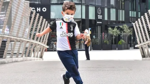 Un pequeño hincha de Juventus jugando al fútbol.
