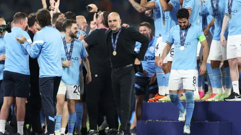 ISTANBUL, TURKEY – JUNE 10: Pep Guardiola, Manager of Manchester City, celebrates while wearing his winners medal as his players celebrates in the background after the team's victory in the UEFA Champions League 2022/23 final match between FC Internazionale and Manchester City FC at Ataturk Olympic Stadium on June 10, 2023 in Istanbul, Turkey. (Photo by Michael Steele/Getty Images)
