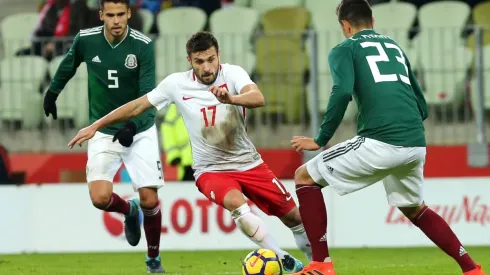 Jakub Kaminski contra Diego Reyes y César Montes en un amistoso entre México y Polonia.
