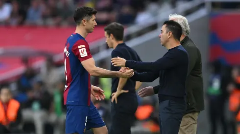 Lewandowski y Xavi se saludan.