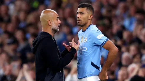 Pep Guardiola platica con Rodri
