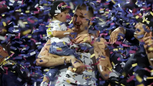 Nikola Jokić celebra junto a su hija la obtención del campeonato de la NBA.
