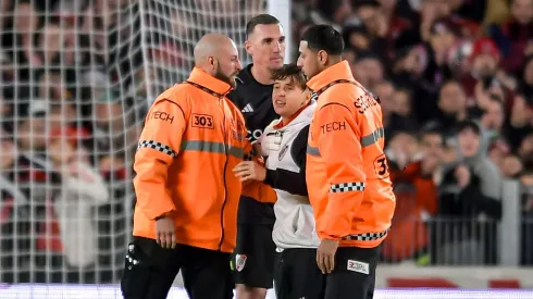 Armani junto al chico que se metió al campo.
