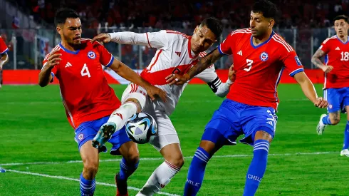 Paolo Guerrero, de Perú, lucha contra dos rivales chilenos.