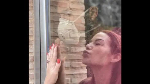 Ezequiel Garay y Tamara Gorro se besan a través de un vidrio
