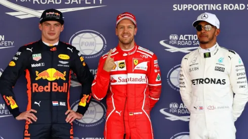 Sebastian Vettel (el de rojo) celebra un triunfo por Ferrari entre Max Verstappen y Lewis Hamilton
