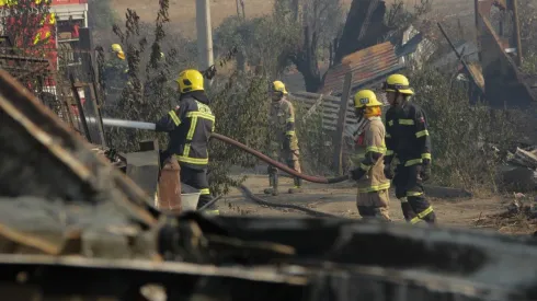 Casas y vehículos destruidos tras incendio forestal.
